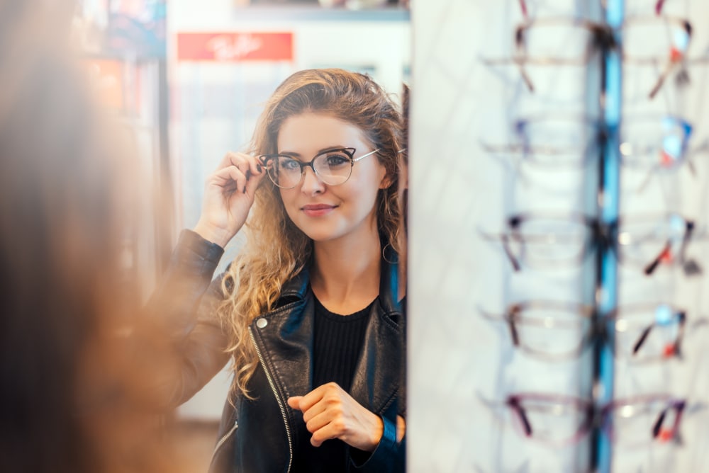 femme teste lunettes chez opticien